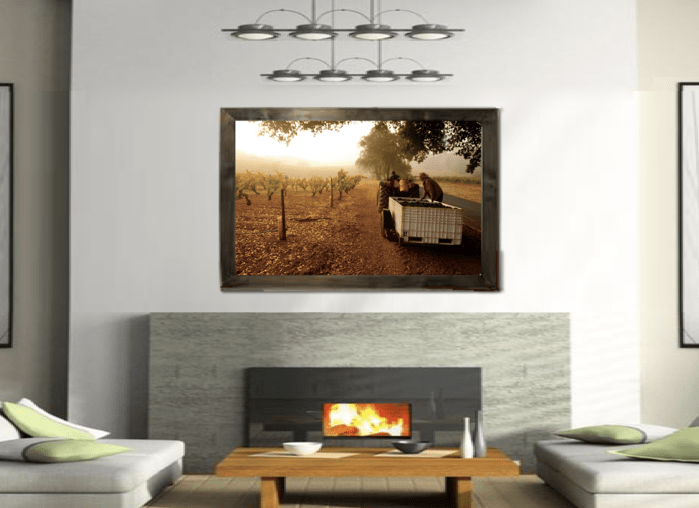 Picture of harvesters in vineyard over a fireplace in a living room
